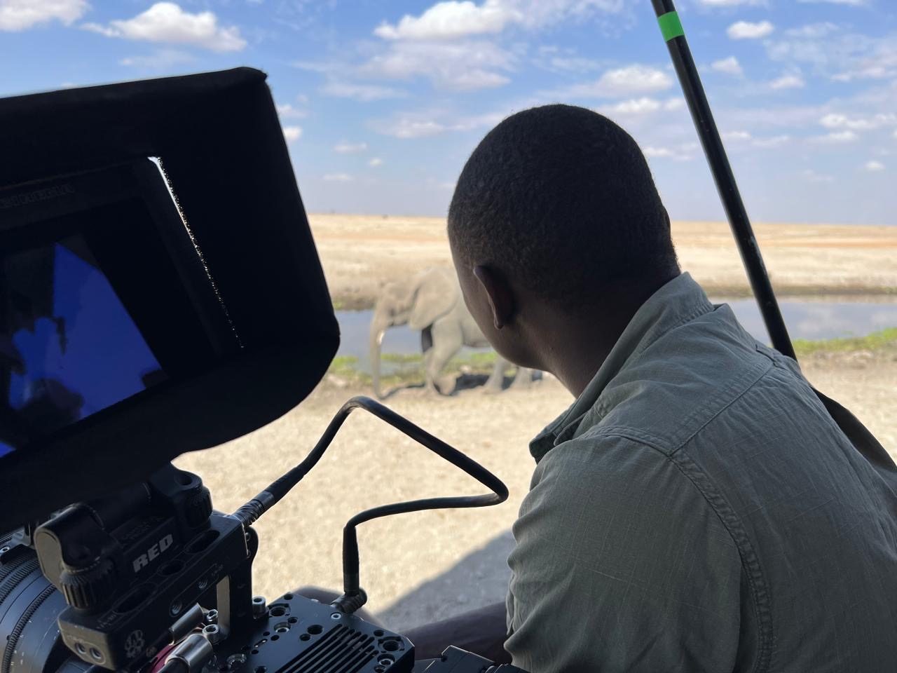 Wickliffe Odera at the monitor, watching elephants at a waterhole through the long lens